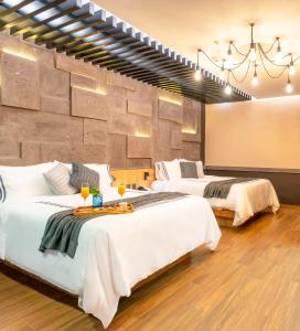 una camera d'albergo con due letti e una parete di Hotel Patio Santiago a Querétaro