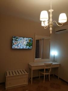 a room with a desk and a mirror and a chandelier at Dionisia Apartments 2 in Kefalos