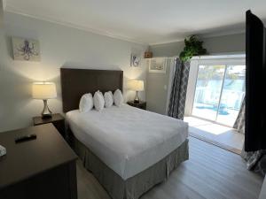 a bedroom with a bed with two lamps and a window at Marco Island Lakeside Inn in Marco Island