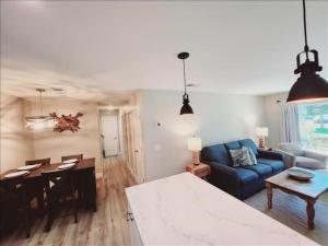 a living room with a blue couch and a table at J7 completely renovated, 2 pools, pickleball, fishing, fitness center,easy walk to pier in Mallory Park +21 photos