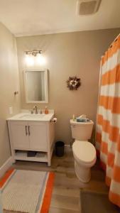 a bathroom with a toilet and a sink and a mirror at J7 completely renovated, 2 pools, pickleball, fishing, fitness center,easy walk to pier in Mallory Park