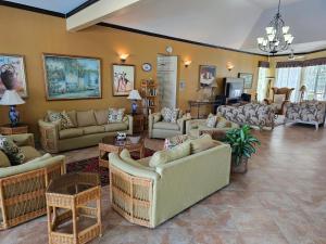 una gran sala de estar con sofás y mesas. en Spicy Hill Villa, en Port Antonio