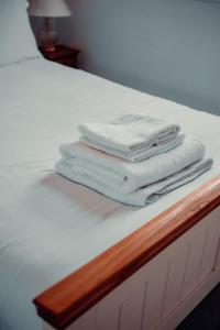 - une pile de serviettes assises au-dessus d'un lit dans l'établissement W London apt for 4. Open plan kitchen/living room, à Londres