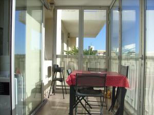 a table on a balcony with a table and chairs at Studio type T1 avec parking et cave à 600 m de la plage in Fréjus