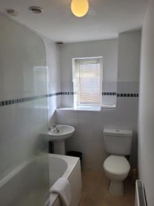 Baño blanco con aseo y lavamanos en Rent Unique the Otford modern home 1 bed with mezzanine en Crawley