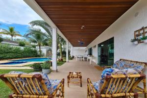 a patio with two deck chairs and a pool at Casa com piscina e churrasqueira no Guarujá in Guarujá