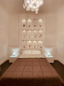 a bedroom with a large bed and a chandelier at Dimora Falcone in Bari