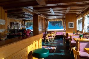 コルヴァーラ・イン・バディーアにあるHotel Planacのバー、テーブル、椅子が備わるレストラン