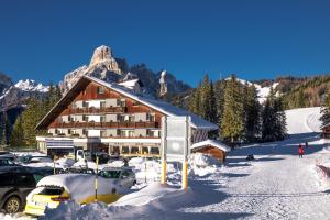 a ski lodge with a lot of snow in front of it at Hotel Planac in Corvara in Badia