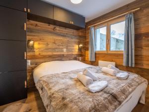 a bedroom with a bed with two towels on it at Appartement rénové au cœur de l'Alpe d'Huez avec Wifi et Parking - FR-1-645-24 in LʼHuez