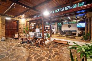 a large living room with wooden ceilings and a stone floor at Villa Havana in Mal País