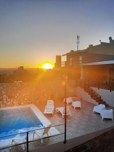 puesta de sol sobre un edificio con piscina y sillas en A mi manera - Casa de Sierra en Villa Giardino