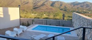 una piscina en un balcón con montañas en el fondo en A mi manera - Casa de Sierra en Villa Giardino