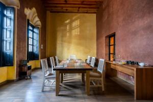 uma sala de jantar com uma mesa de madeira e cadeiras em Hotel Patio Santiago em Querétaro