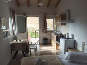 a kitchen with a table and a small kitchen with a table and a kitchen at Christos Family Apartments Β in Ágios Rókkos