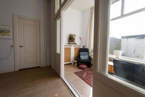 a hallway with a door and a chair and a window at City House Hoorn in Hoorn