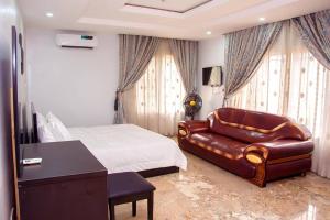 Modern Luxury Home W/ 24H Power Wi-Fi & Security في أبوجا: غرفة نوم بسرير واريكة جلدية