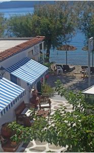 a building with a table and benches and the beach at Blu in Glida