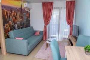 a living room with a blue couch and red curtains at Flatiron Apartments Skopje in Skopje