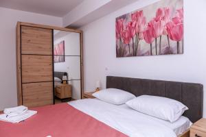 een slaapkamer met een bed en een schilderij aan de muur bij Flatiron Apartments Skopje in Skopje