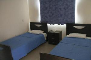 two beds in a room with blue sheets at Maricosta Villas in Protaras +30 photos