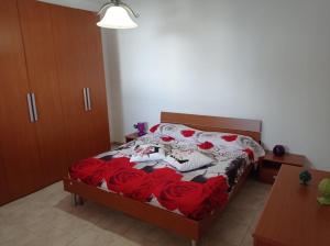 Un dormitorio con una cama con rosas rojas. en Villa Malù, en San Pietro in Bevagna