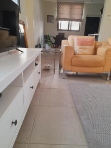 sala de estar con sofá y TV en Beautiful Home - 2 Double Rooms en Accra