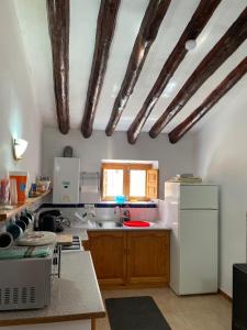 a kitchen with a white refrigerator and wooden cabinets at 2 bed cottage Lorca many hiking & cycling trails in Lorca