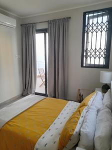 a bedroom with a large bed with a yellow blanket at Beautiful Home - 2 Double Rooms in Accra