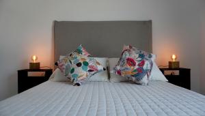 a bedroom with a bed with pillows and two candles at Casa Atilio -Dpto Premium con entrada autónoma in Rafaela