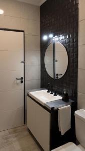 een badkamer met een wastafel en een spiegel bij Casa Atilio -Dpto Premium con entrada autónoma in Rafaela