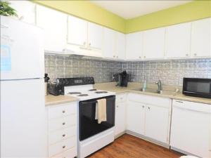 cocina con armarios blancos y fogones negros en S3, comfy, close to pickleball, en Mallory Park