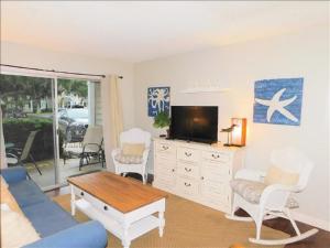 Una sala de estar con un sofá azul y un televisor en S3, comfy, close to pickleball, en Mallory Park