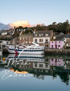 a boat is docked in a harbor with houses at Padstow Escapes - Teyr Luxury Penthouse Apartment in Padstow