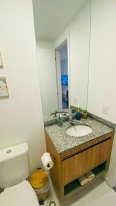 uma casa de banho com um lavatório, um WC e um espelho. em Liberdade SP a 250m do metrô em São Paulo