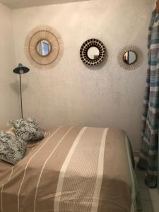 a bedroom with two mirrors on the wall and a bed at Appartement vue mer les pieds dans l'eau in Collioure