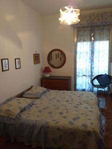 um quarto com uma cama, uma cadeira e uma janela em MareMonti em Marinella di Sarzana