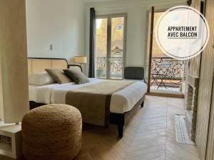 a bedroom with a bed with a ottoman and a window at Centre historique Dijon "Le Charmant" et "Le Charmant Bis" in Dijon