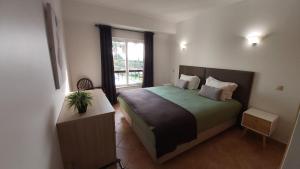 Un dormitorio con una cama grande y una ventana en Clube Alvor Ria - Waterfront luxury apartments with stunning views, en Alvor