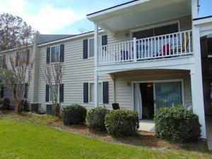 a large white house with a balcony and bushes at W2 Ocean Walk Resort upstairs 2 bed king and two twins next to back pool in Saint Simons Island