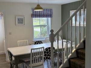 ein Esszimmer mit einem Tisch und einer Treppe in der Unterkunft Dragonfly Cottage in Filey