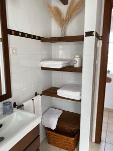 uma casa de banho com toalhas, um lavatório e um espelho em Casa Maida em Tetir