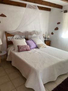 a bedroom with a large white bed with pillows at Casa Maida in Tetir