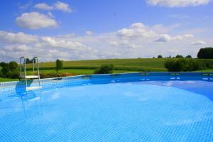 a large swimming pool with a view of a field at Maison Marigoule - Perfect with kids & families in Mialet