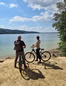 a man and a woman standing with bikes on a beach at Jasna Chata Kluszkowce in Kluszkowce