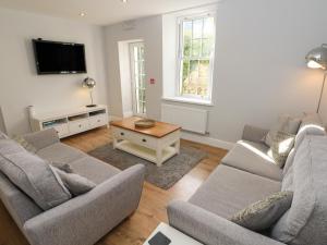 a living room with two couches and a tv at Harbour Beach at The Hideaway in Tenby
