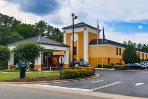 a yellow and white building with a parking lot at Quality Inn Richmond Airport in Sandston