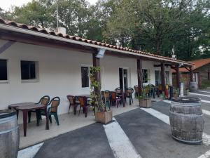 un patio con sillas y mesas y un edificio en Mobilhome proche du Puy du Fou en La Boissière-de-Montaigu