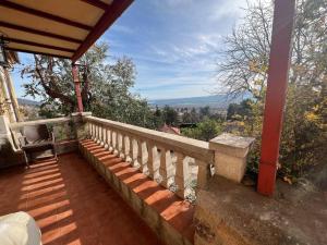 Un balcón de una casa con una mesa y una silla en Casa independiente 4 habitaciones en Miraflores de la Sierra