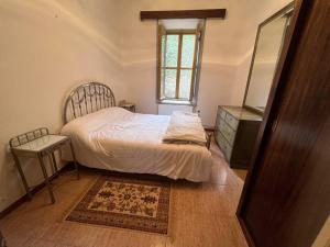 1 dormitorio con cama, tocador y espejo en Casa independiente 4 habitaciones en Miraflores de la Sierra